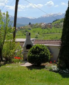 a view from the garden of a house with mountains in the background at Holiday Home Zelena Oaza in Sarajevo