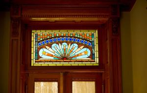 a stained glass window over a wooden door at Wentworth Mansion in Charleston