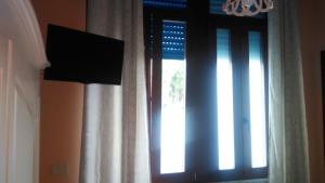 バーリにあるPerla Del Mareの窓、テレビ、カーテンが備わる客室です。