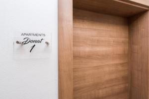 a wooden door with a sign that reads participants donate at Apartments Donat in Zadar