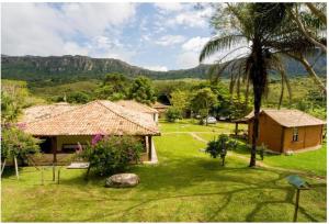 a house with a palm tree and a house with a yard at Calcada Sao Jose in Tiradentes