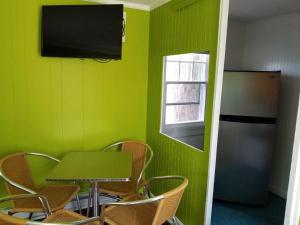 a green room with a table and a refrigerator at Lighthouse Cabins in Old Orchard Beach