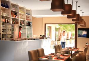 a woman standing at a bar in a restaurant at Seventeen Hotel in Valbonne