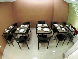 a group of tables and chairs with plates on them at Hotel Conexão Pampulha in Belo Horizonte +19 photos