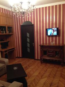 ein Wohnzimmer mit einem TV an einer gestreiften Wand in der Unterkunft Apartment SOFI in Tbilisi City