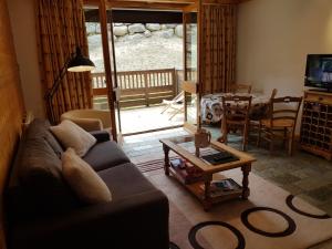 a living room with a couch and a table at Un été à Courchevel in Courchevel