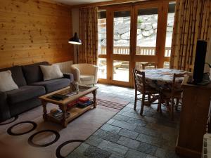 a living room with a couch and a table at Un été à Courchevel in Courchevel