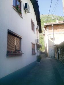 un callejón entre dos edificios con flores en las ventanas en Guesthouse NO.27, en Mostar