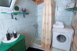 uma casa de banho com uma máquina de lavar roupa e um chuveiro. em Mare di l'angeli em Lévktron