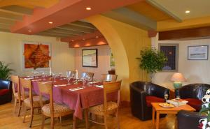 バルヌヴィル・カルトゥレにあるオテル レストラン ル キャップのダイニングルーム(長いテーブルと椅子付)