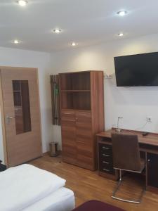a bedroom with a desk and a bed and a computer at Pension "Zum Raubritter" in Langquaid +20 photos