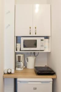 Premium Studio by MRG Apartments في بوخارست: طاولة مطبخ مع ميكروويف وآلة صنع قهوة