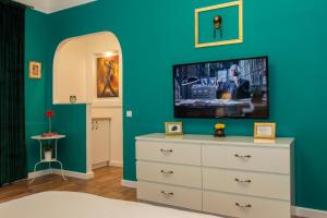 a bedroom with a tv on a blue wall at Premium Studio by MRG Apartments in Bucharest