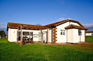 a small white house in a field of grass at Stoneleigh Village in Sidmouth