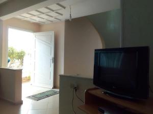 uma televisão sentada numa bancada numa sala com uma porta em villa avec jardin em Saïdia