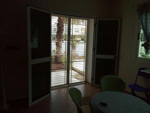 Zimmer mit Glastür, Tisch und Stühlen in der Unterkunft villa avec jardin in Saidia 