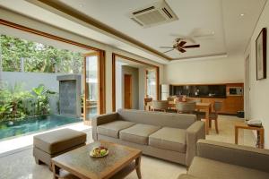 a living room with a couch and a table at KoenoKoeni Villa in Seminyak