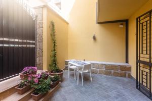 a patio with a table and some plants and flowers at B&B Medusa in Santa Flavia