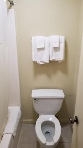 a bathroom with a white toilet and towels at Greenfield Inn in Greenfield