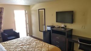 a hotel room with a bed and a flat screen tv at Greenfield Inn in Greenfield