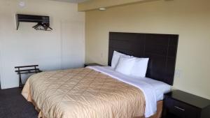 1 dormitorio con 1 cama grande y cabecero marrón en Greenfield Inn, en Greenfield