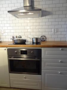 a kitchen with a stove with two pans on it at Villa gruddbo in Sollerön