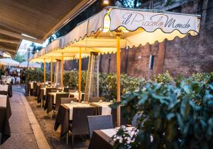 un ristorante con tavoli, sedie e un ombrellone di LUX Suites in Roma a Roma
