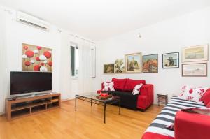 a living room with a red couch and a tv at Apartment Leo in Split