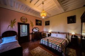 a bedroom with two beds and a chandelier at Castello di Valenzano in Arezzo