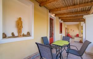 a patio with a table and chairs and a statue at Olive Tree Apartment in Lagópodhon