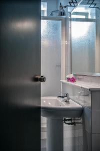 bagno con lavandino e specchio di Hotel Santa Chiara a Nocera Inferiore