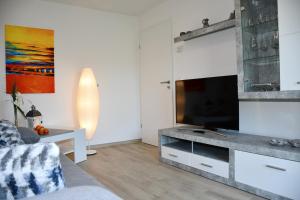 sala de estar con TV de pantalla plana en la barra en Eifellounge, en Monschau