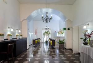 una sala da pranzo con lampadario pendente, tavoli e sedie di Hotel Santa Chiara a Nocera Inferiore