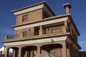 un grand bâtiment en briques avec un balcon. dans l'établissement Casa Pedro, à Roquetas de Mar