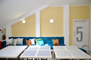 a room with a blue couch and two tables at Hostel Pupa in Kotor