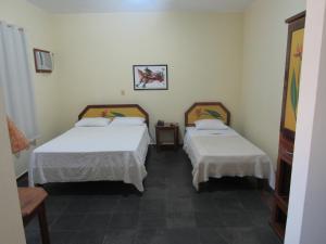 a room with two beds and a table at Alfenas Palace Hotel in Alfenas