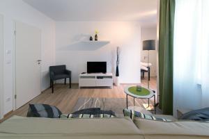 uma sala de estar com um sofá e uma televisão em Vilelo Ferienwohnen em Friedrichshafen