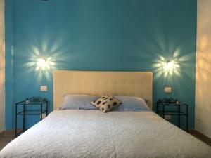 a bedroom with a bed with blue walls and two end tables at Albamare in Monterosso al Mare