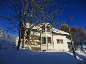 una casa blanca con nieve en el suelo en Ferienwohnung Alte Poststraße, en Kurort Oberwiesenthal