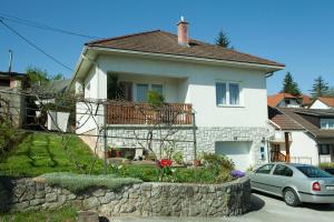 une maison blanche avec un balcon et une voiture dans l'établissement Rooms Maria, à Slunj