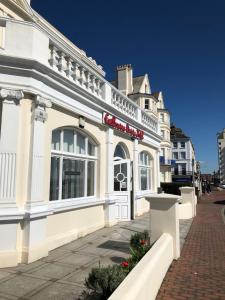 a white building on the side of a street at Eastbourne Riviera Hotel in Eastbourne