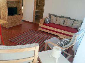 ein Wohnzimmer mit einem Bett, einem Tisch und Stühlen in der Unterkunft Casas das Amoreiras in Aldeia do Meco