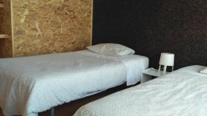 two beds in a hotel room with white sheets at Casas das Amoreiras in Aldeia do Meco