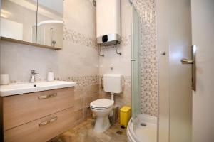 a bathroom with a toilet and a sink and a shower at Apartment Noah in Zadar +15 photos
