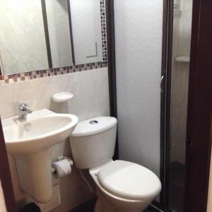 a bathroom with a toilet and a sink at Hotel Casa Medina in San Mateo