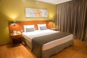 ein Schlafzimmer mit einem großen Bett in einem Hotelzimmer in der Unterkunft Plaza Barra First in Rio de Janeiro