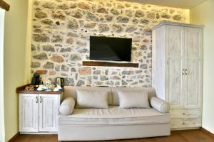 un salon avec un canapé contre un mur en pierre dans l'établissement Manolia, à Hydra