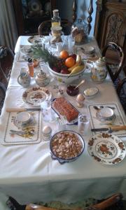 una mesa con un mantel blanco con comida. en B&B Les Fleurettes, en Lomazzo