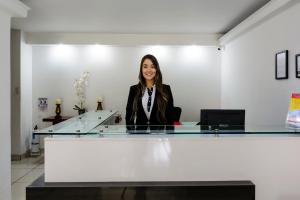 a woman sitting at a desk in an office at Hotel Florida Inn in Medellín