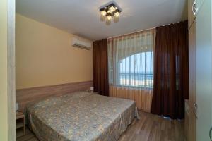 a bedroom with a bed and a large window at Sea Panorama Apartments Golden sands in Golden Sands